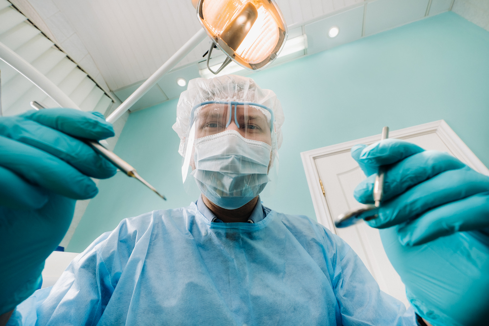 a dentist wearing a protective mask sits nearby an 2021 12 13 18 53 08 utc 1